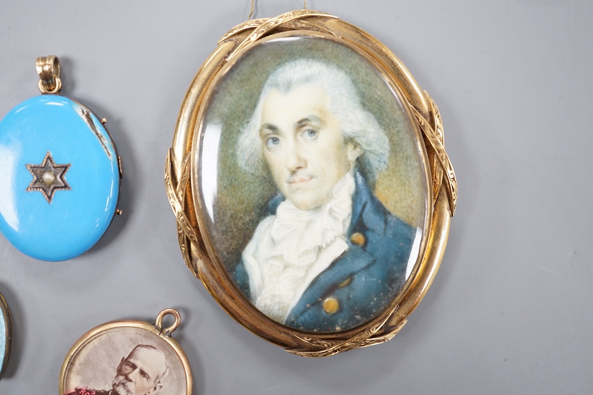 A 19th century yellow metal miniature oval portrait mourning brooch, 54mm, two enamelled lockets(a.f.) and one other small pendant.